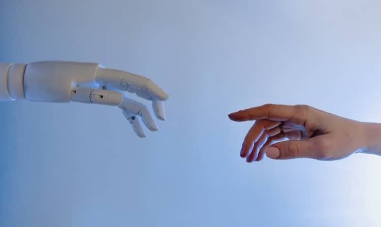 Een robothand en een menselijke hand benaderen elkaar